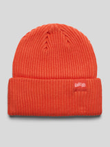 Rückseite der orangefarbenen Strickmütze mit rotem Label „Kaulitz Hills“ auf dem Bund.