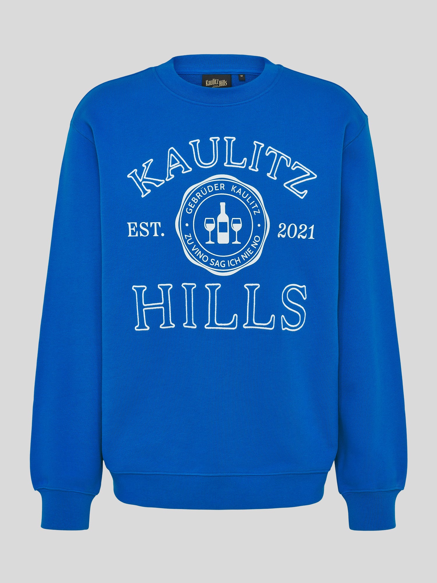 Blauer Kaulitz Hills Sweatshirt mit großem weißen Frontprint/Stick „KAULITZ HILLS EST. 2021“ und Rundlogo mit Weinflasche und Gläsern.