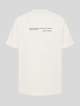 Rückansicht eines oversized Kaulitz Hills T-Shirts in Cremeweiß mit schwarzem Zitatdruck und Bill-Kaulitz-Signatur im oberen Rückenbereich.