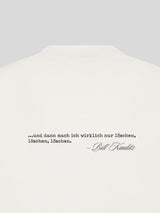 Detailaufnahme der Rückseite eines cremeweißen Kaulitz Hills T-Shirts mit schwarzem Zitatdruck „…und dann mach ich wirklich nur löschen, löschen, löschen.“ und Bill-Kaulitz-Signatur.